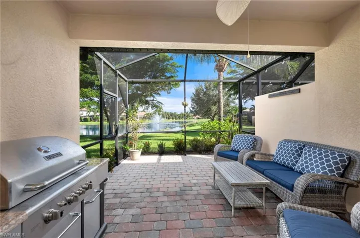 Screened in lanai, grilling area, a water view, and ceiling fan