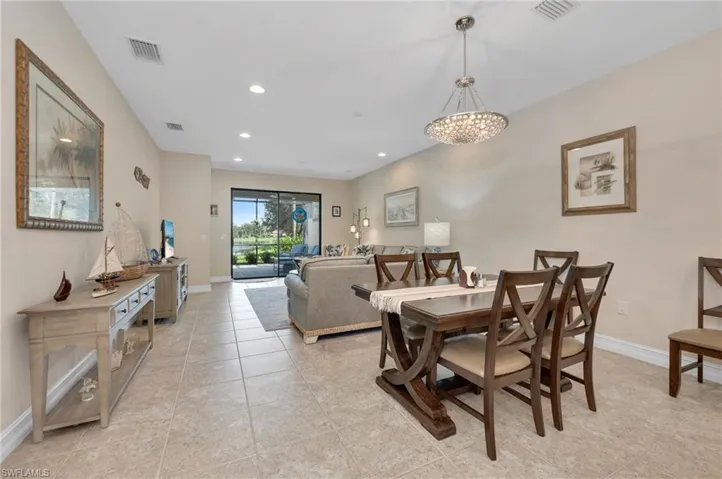 Tiled dining area featuring an inviting chandelier