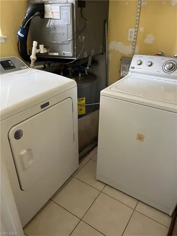Laundry room featuring light tile patterned floors and washing machine and dryer