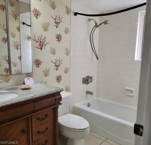 Full bathroom featuring tile patterned flooring, vanity, toilet, and tiled shower / bath