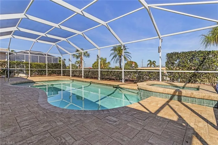 View of pool featuring glass enclosure and a patio area