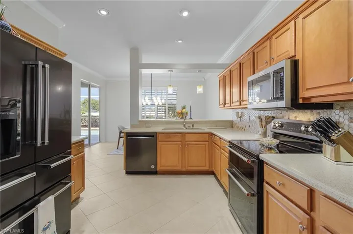 Tiled dining area featuring ceiling fan and ornamental molding