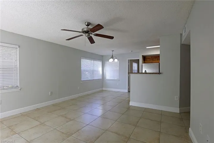 Spare room with suspended lighting, ceiling fan, a textured ceiling, and light tile patterned flooring