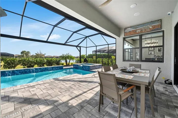 View of swimming pool with pool water feature, a lanai, an in ground hot tub, and a patio
