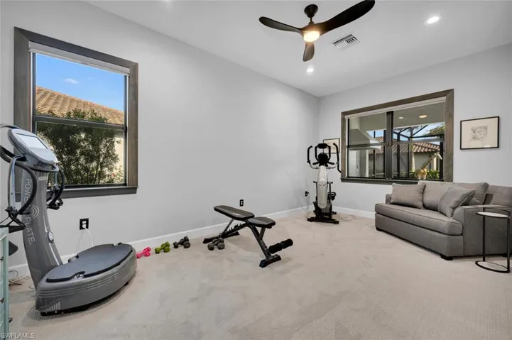 Exercise room with carpet and ceiling fan