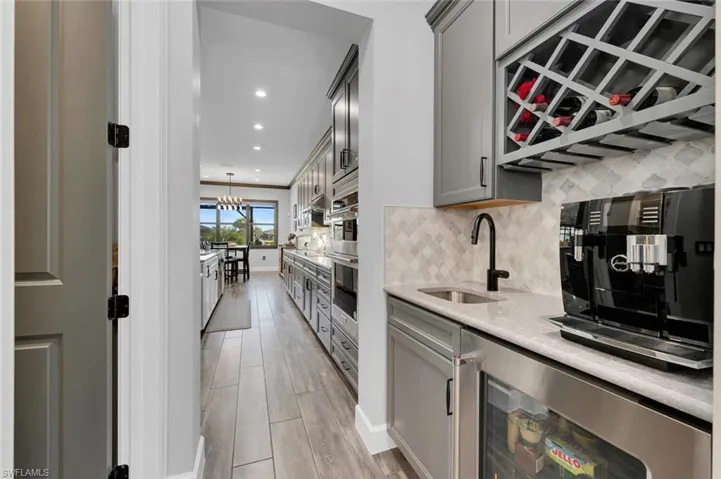 Kitchen featuring gray cabinets, an inviting chandelier, hanging light fixtures, and sink