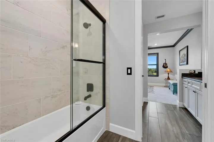 Bathroom with crown molding, vanity, and combined bath / shower with glass door