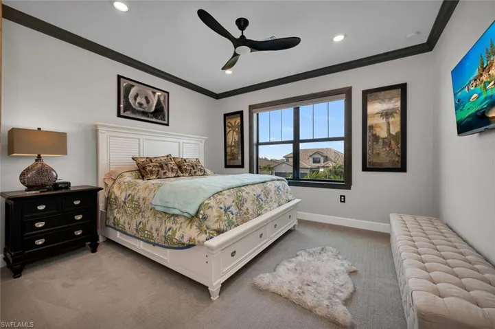 Bedroom with carpet flooring, ceiling fan, and crown molding