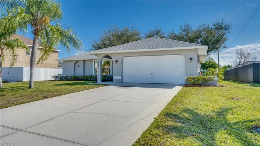 Two car garage with Palm Trees in the front yard.