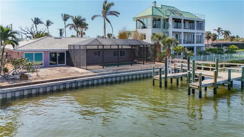 Side view of 5650 Williams.  View of impact windows, dock and cap are in great shape as well as the pool and screened lanai.