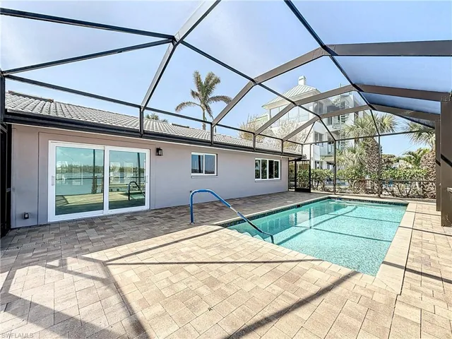 Outdoor pool featuring a patio area, a sunroom, and a lanai