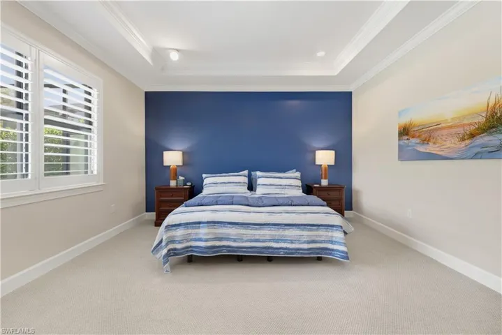 Bedroom with carpet flooring, crown molding, and a tray ceiling
