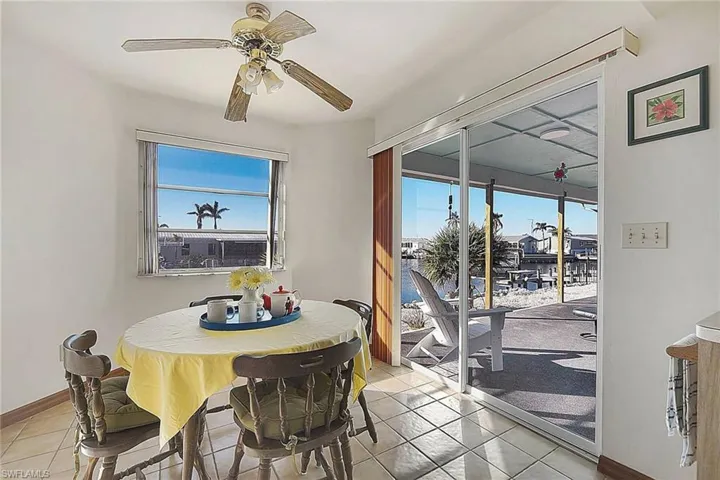 Tiled dining area featuring ceiling fan and baseboards