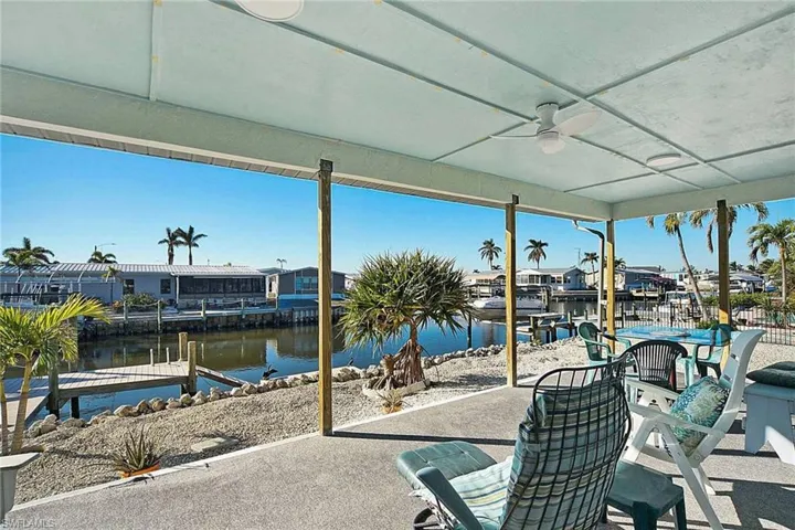View of patio / terrace featuring ceiling fan, a boat dock, a water view, and boat lift