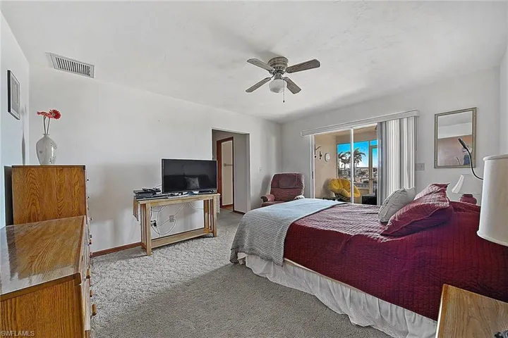 Carpeted bedroom featuring access to outside and a ceiling fan