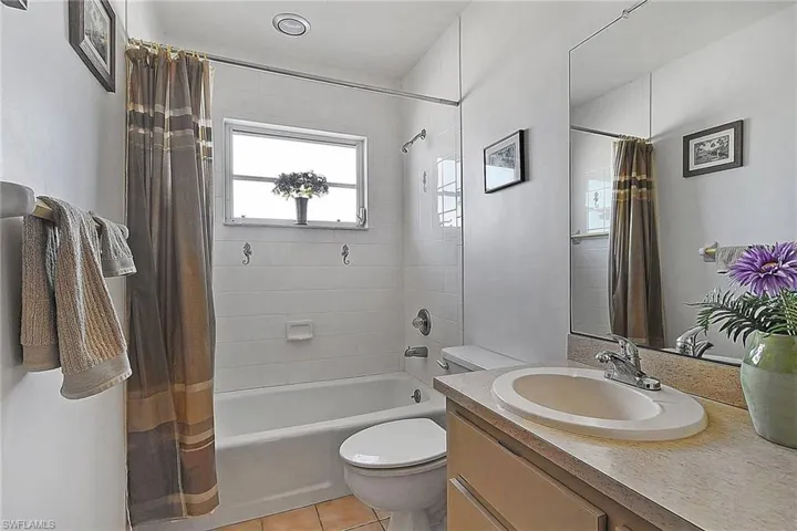 Bathroom featuring shower / bath combo, vanity, and tile patterned floors