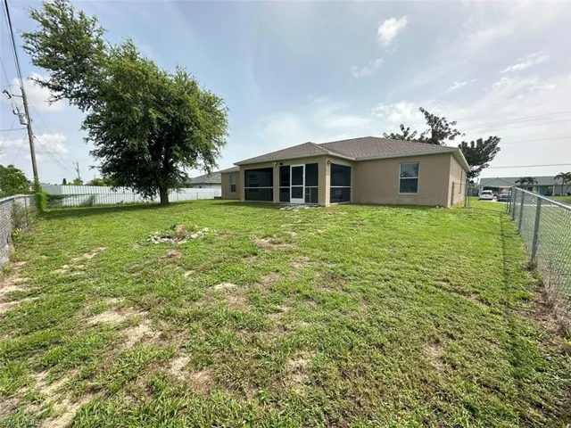 Back of house with a yard