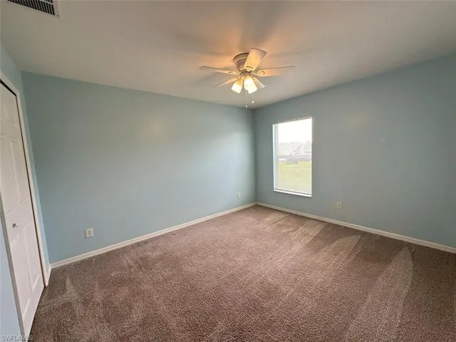 Spare room featuring carpet floors and ceiling fan