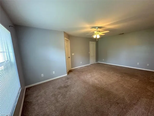 Empty room featuring carpet flooring and ceiling fan