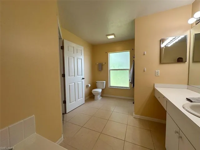 Bathroom with tile patterned flooring, toilet, and vanity