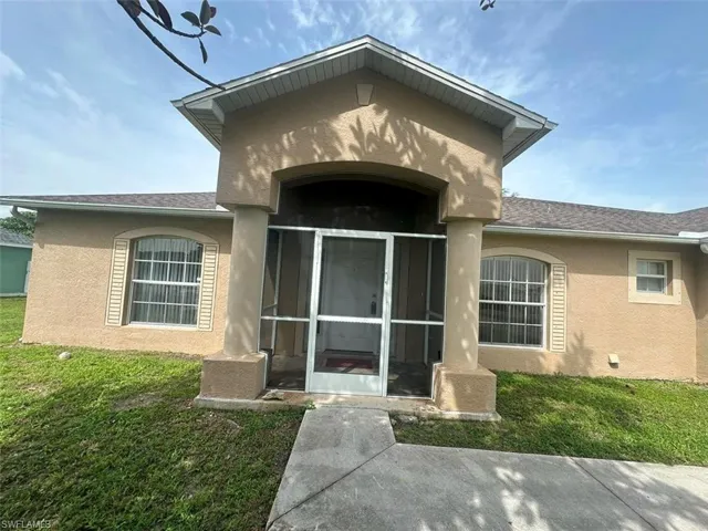 View of exterior entry with a yard
