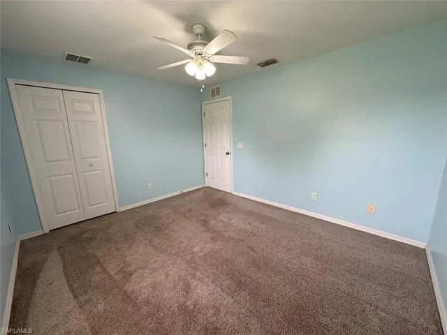 Unfurnished bedroom featuring a closet, carpet floors, and ceiling fan