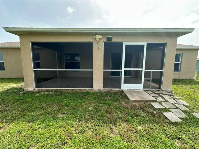 Back of property featuring a yard and a sunroom