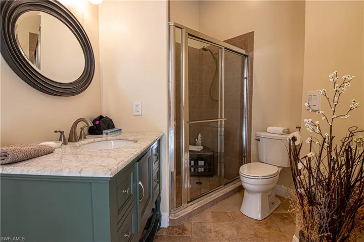 Updated bathroom in hallway leading to the kitchen and the main living area.