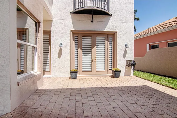 Large paver patio area leading to front double entry doors.
