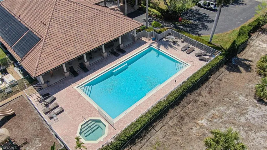 Community pool and spa featuring a patio area and a fenced backyard.