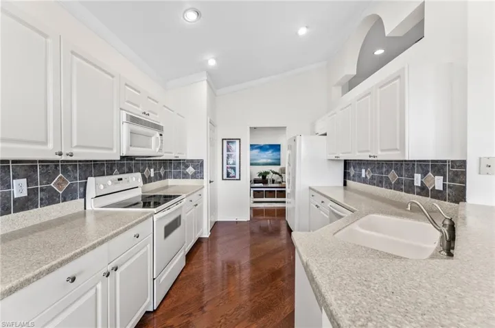 Well appointed kitchen with vaulted ceilings, white/bright cabinetry, pantry and recessed lighting