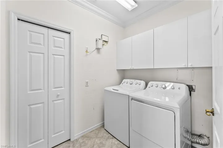 Laundry Room with newer washer/dryer and ample storage, compliments of overhead  cabinets and closet
