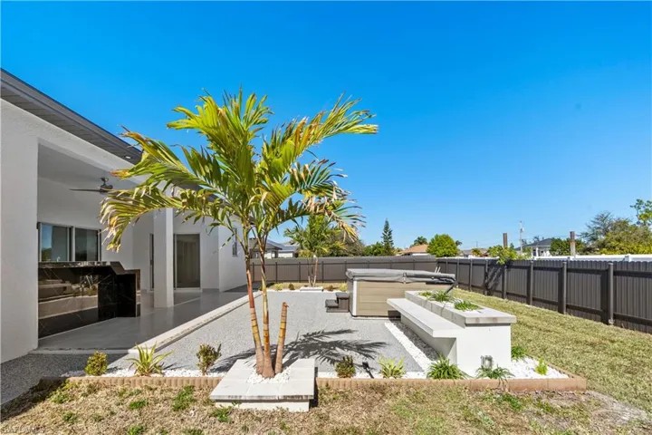 Fenced backyard featuring a patio area, a hot tub, and ceiling fan
