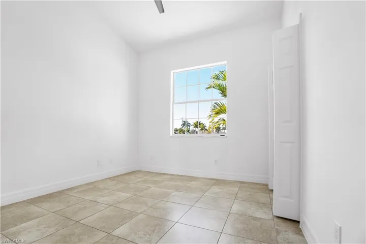 Spare room featuring vaulted ceiling and light tile patterned flooring