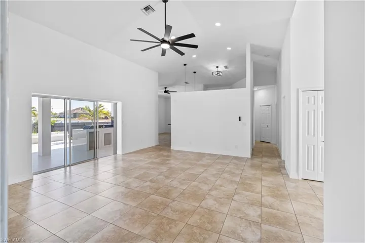 Unfurnished living room featuring a ceiling fan, lofted ceiling, recessed lighting, and light tile patterned floors