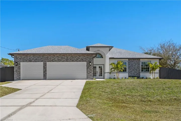 View of front of house with french doors, stucco siding, driveway, a garage, and a shingled roof