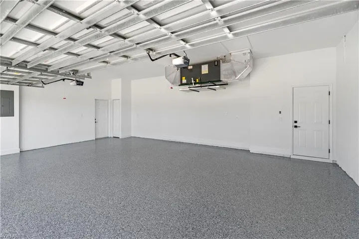 Garage with electric panel and a garage door opener
