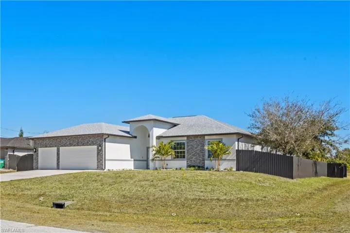Prairie-style home featuring driveway, an attached garage, and stucco siding