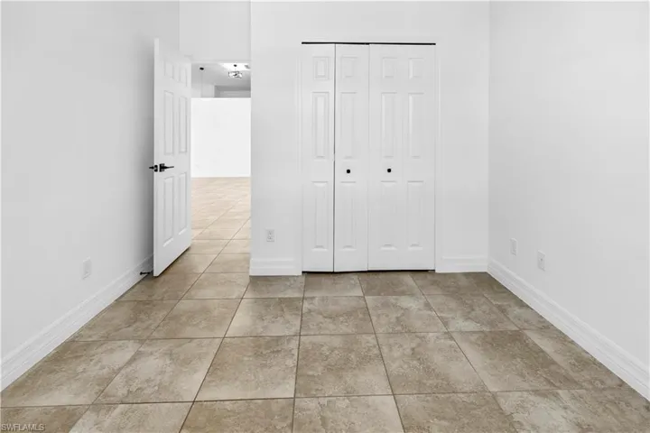 Unfurnished bedroom with a closet and light tile patterned flooring