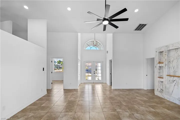 Entryway featuring french doors, ceiling fan, a high ceiling, and recessed lighting