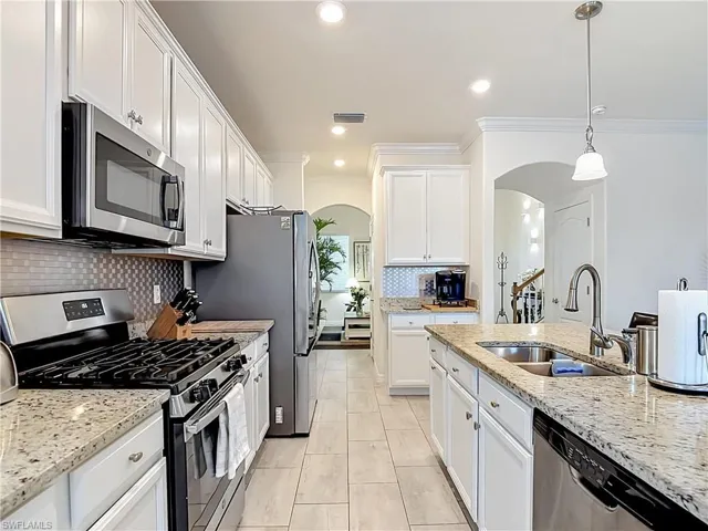 Kitchen with white cabinetry, stainless steel appliances and granite countertops