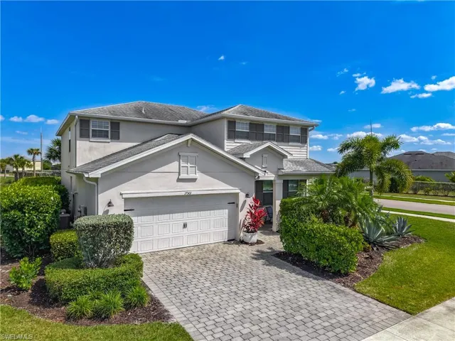 Contemporary two-story residence featuring a paver driveway, an attached two-car garage, and a stucco exterior