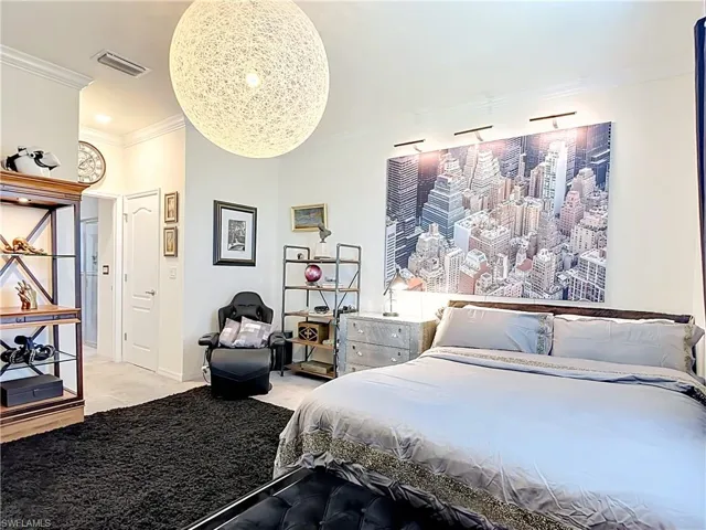 Spacious Primary Bedroom featuring light-colored walls and crown molding