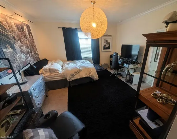 Room featuring crown molding, a built-in window with horizontal blinds, and a large decorative light fixture