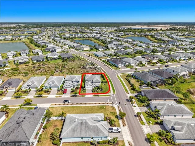 Aerial perspective showcasing a residential community with numerous single-story homes, many featuring private water access