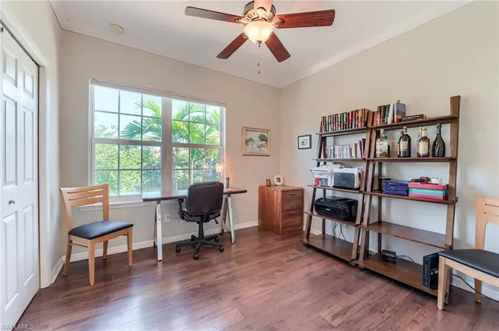 Office area featuring crown molding, ceiling fan, and dark wood-style flooring