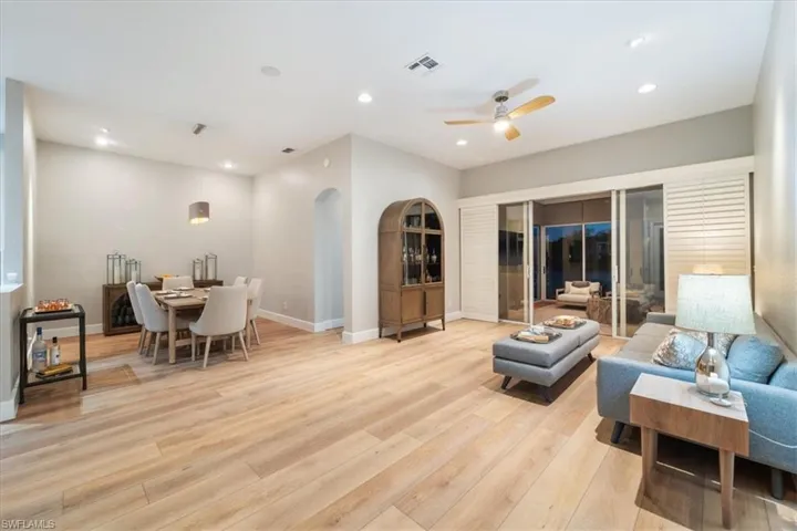 Living area featuring recessed lighting, visible vents, arched walkways, and light wood finished floors