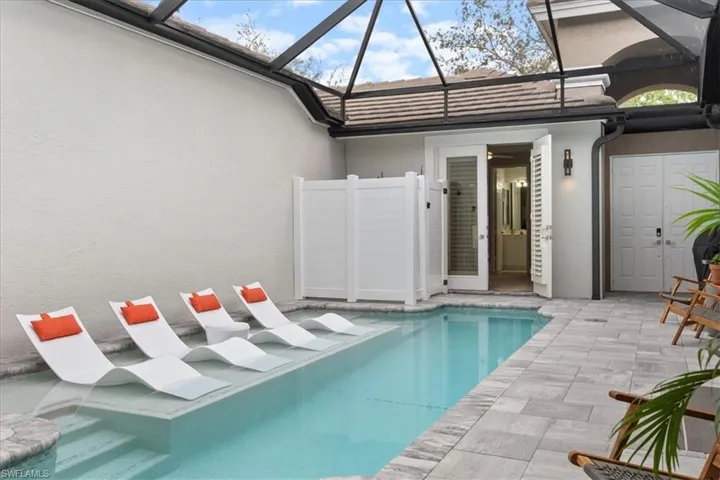 Pool with a patio area and glass enclosure