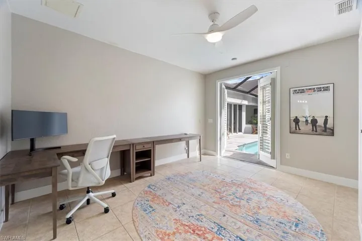 Office space with tile patterned flooring, visible vents, and baseboards