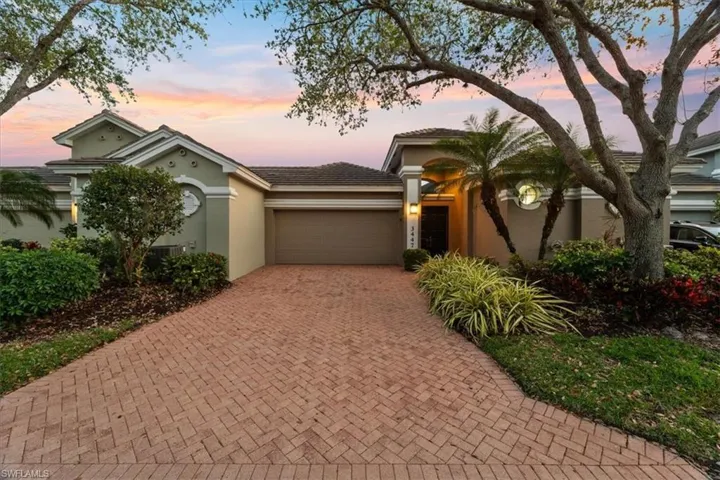 View of front of property with a garage, decorative driveway, and stucco siding